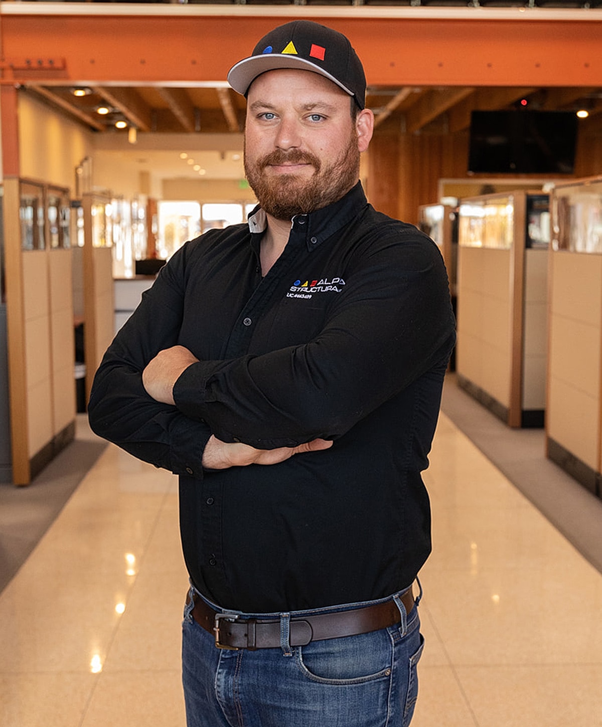 Man posing confidently in an office environment.