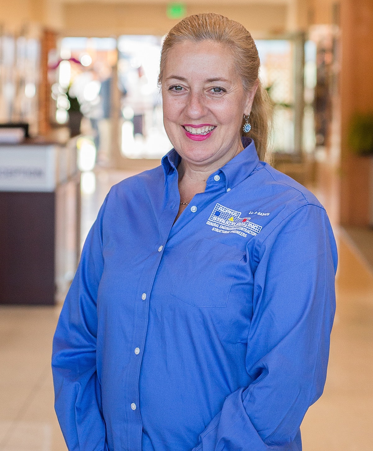 Smiling woman in blue shirt indoors